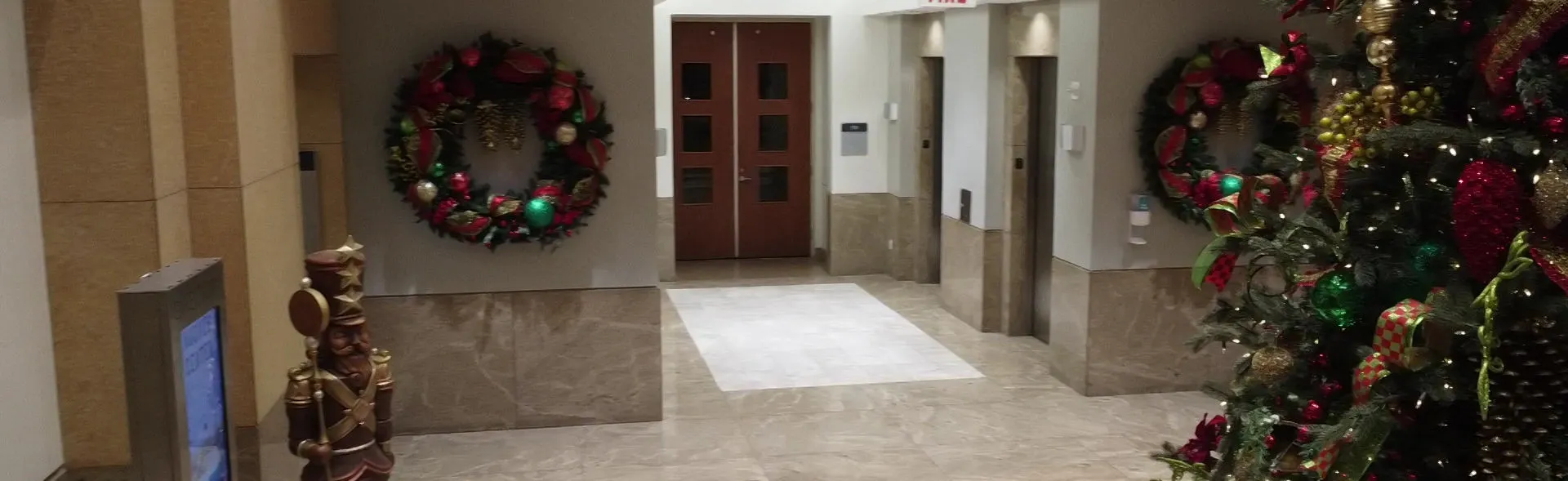 A warmly decorated hotel lobby with a Christmas tree and wreath